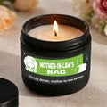 Candle in a container labeled 'Mother-in-Law's Nag' with a green label on a neutral background.